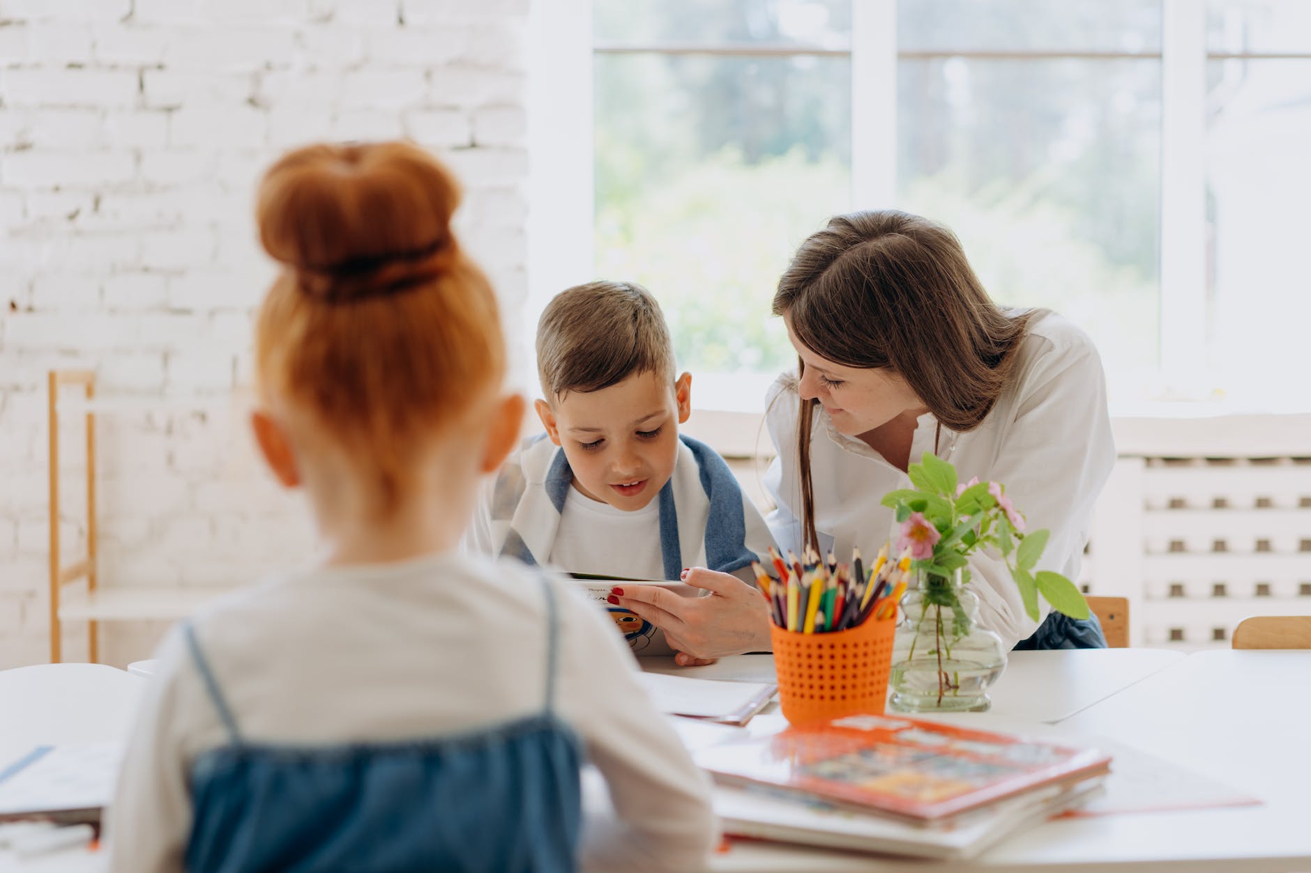 a woman sitting beside a boy reading